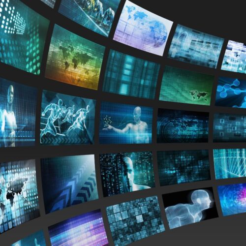 Digitale Wand mit zahlreichen Bildschirmen, die futuristische Visualisierungen zeigen – darunter künstliche Intelligenz, Datenströme, humanoide Figuren und Weltkarten; Symbolbild für technologische Entwicklung und künstliche Intelligenz.