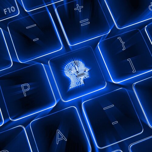 Leuchtend blaue Computertastatur mit hervorgehobener Taste, die ein stilisiertes Profil eines menschlichen Kopfes mit Leiterbahnen zeigt – Symbol für künstliche Intelligenz und digitale Denkprozesse.